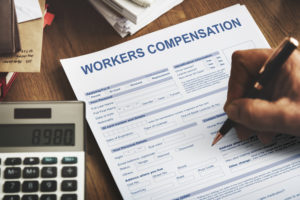 Injured Man Filling Insurance Claim Form - Workers Compensation Accident Injury Concept